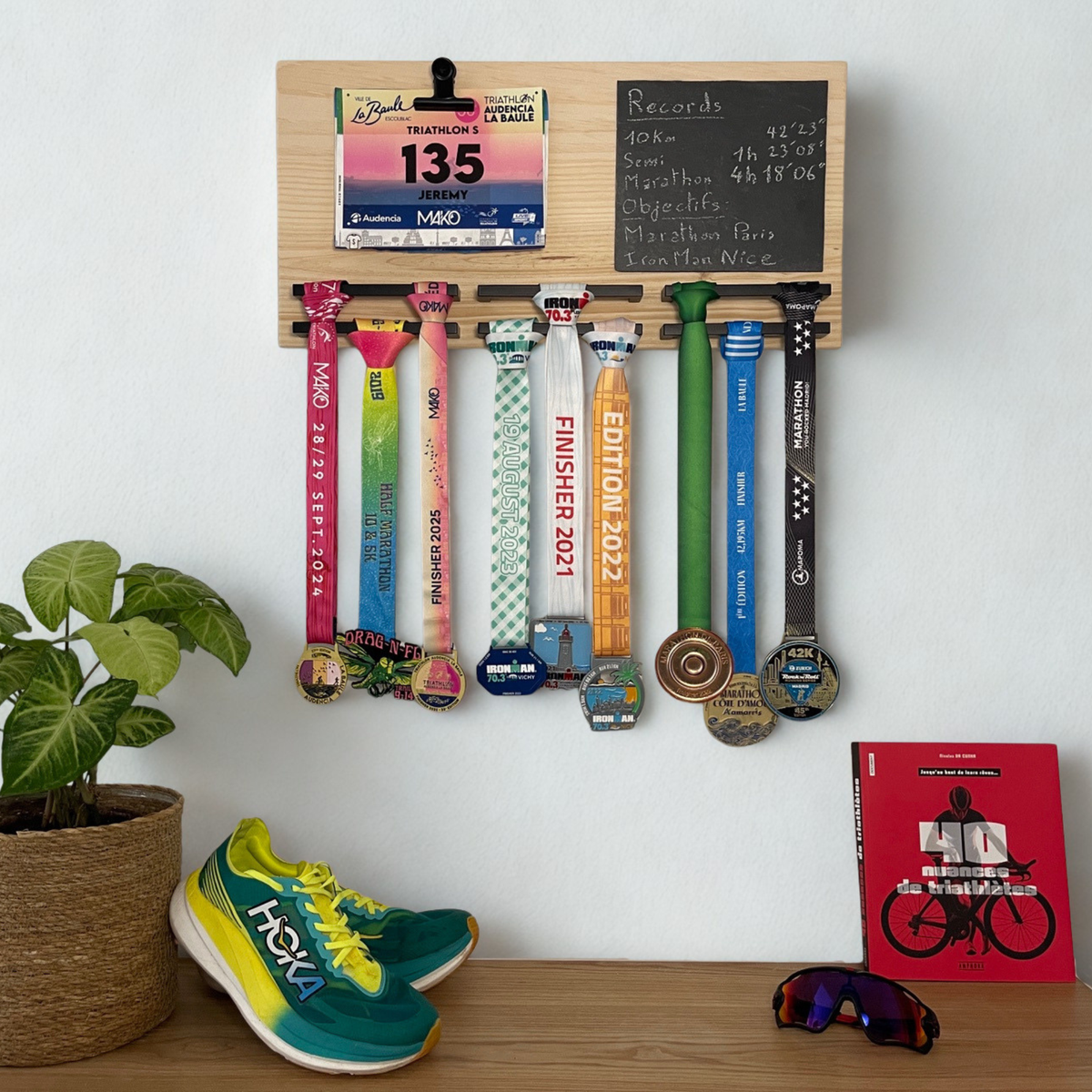 Porte-médailles mural en bois avec médailles de course et dossard exposés dans un intérieur moderne